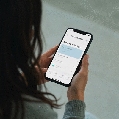 Person using a mobile banking app to set up automated savings