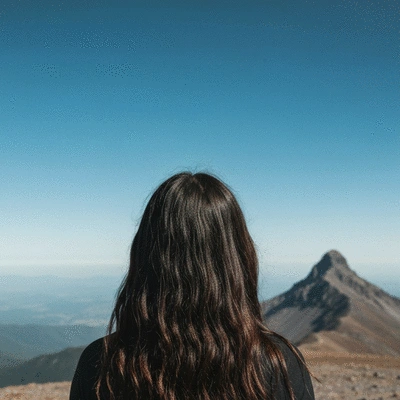 Person looking at a distant mountain peak, symbolizing motivation and overcoming challenges